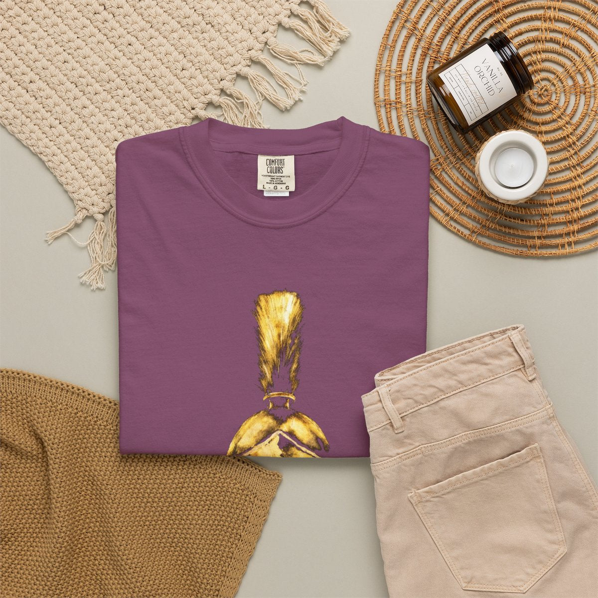 Berry casual tee folded in a flat-lay, gold Praetorian helmet on the front