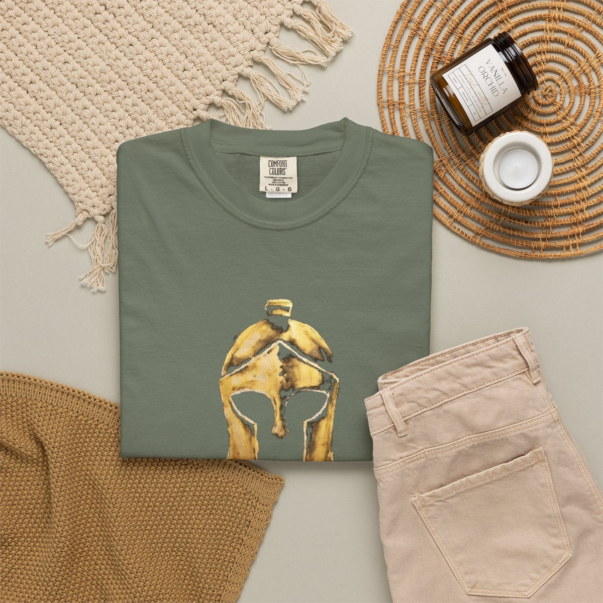 Moss casual tee folded in a flat-lay, gold Helm helmet on the front