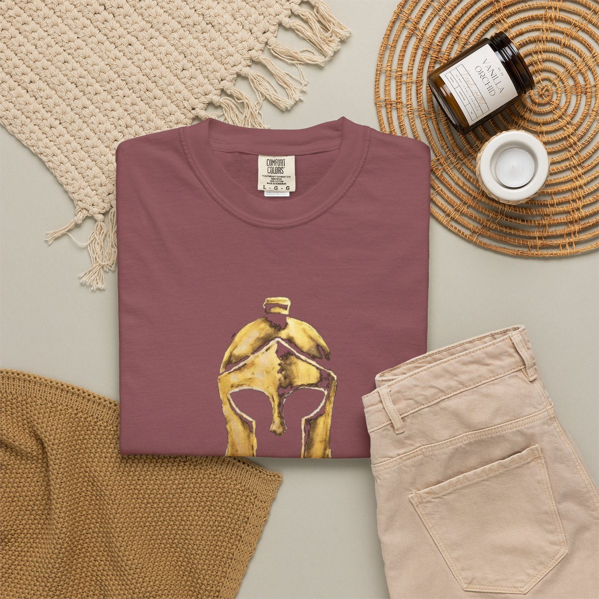 Brick casual tee folded in a flat-lay, gold Helm helmet on the front