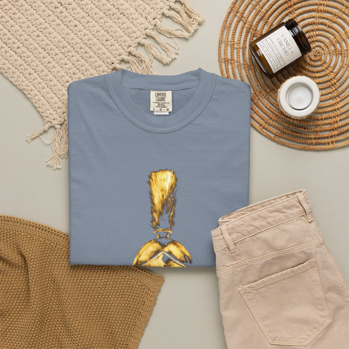 Blue Jean casual tee folded in a flat-lay, gold Praetorian helmet on the front