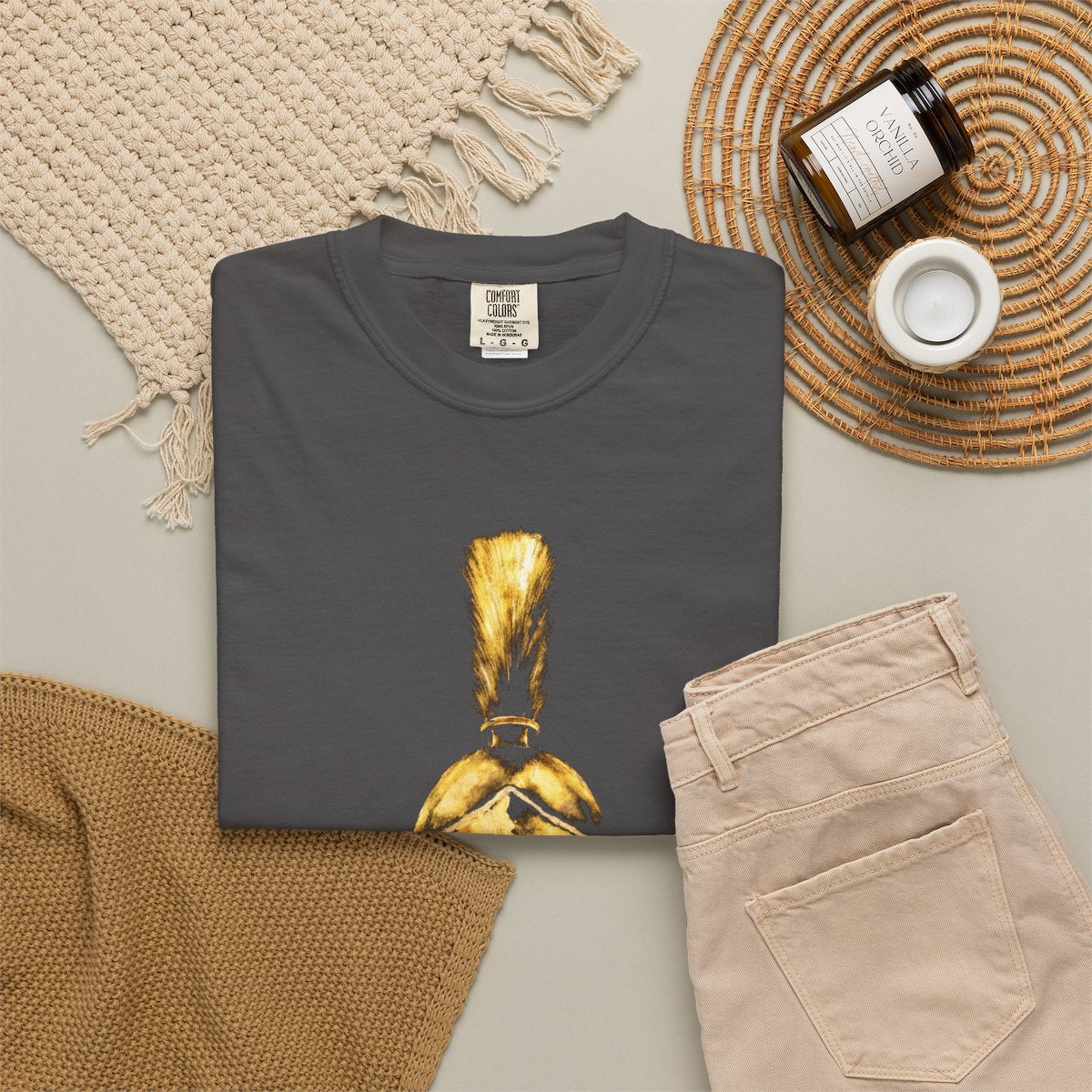 Graphite casual tee folded in a flat-lay, gold Praetorian helmet on the front