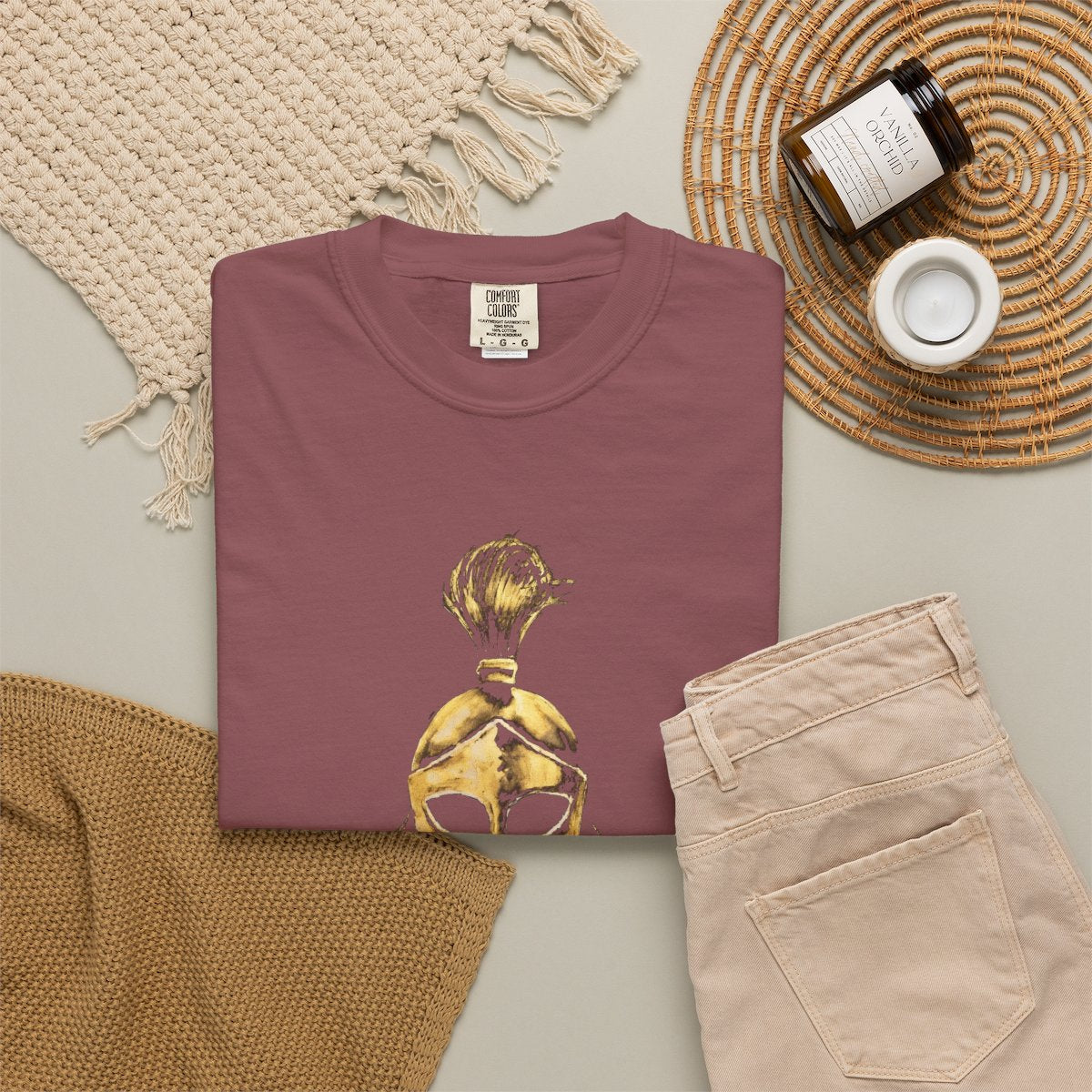 Brick casual tee folded in a flat-lay, gold Sentinel helmet on the front
