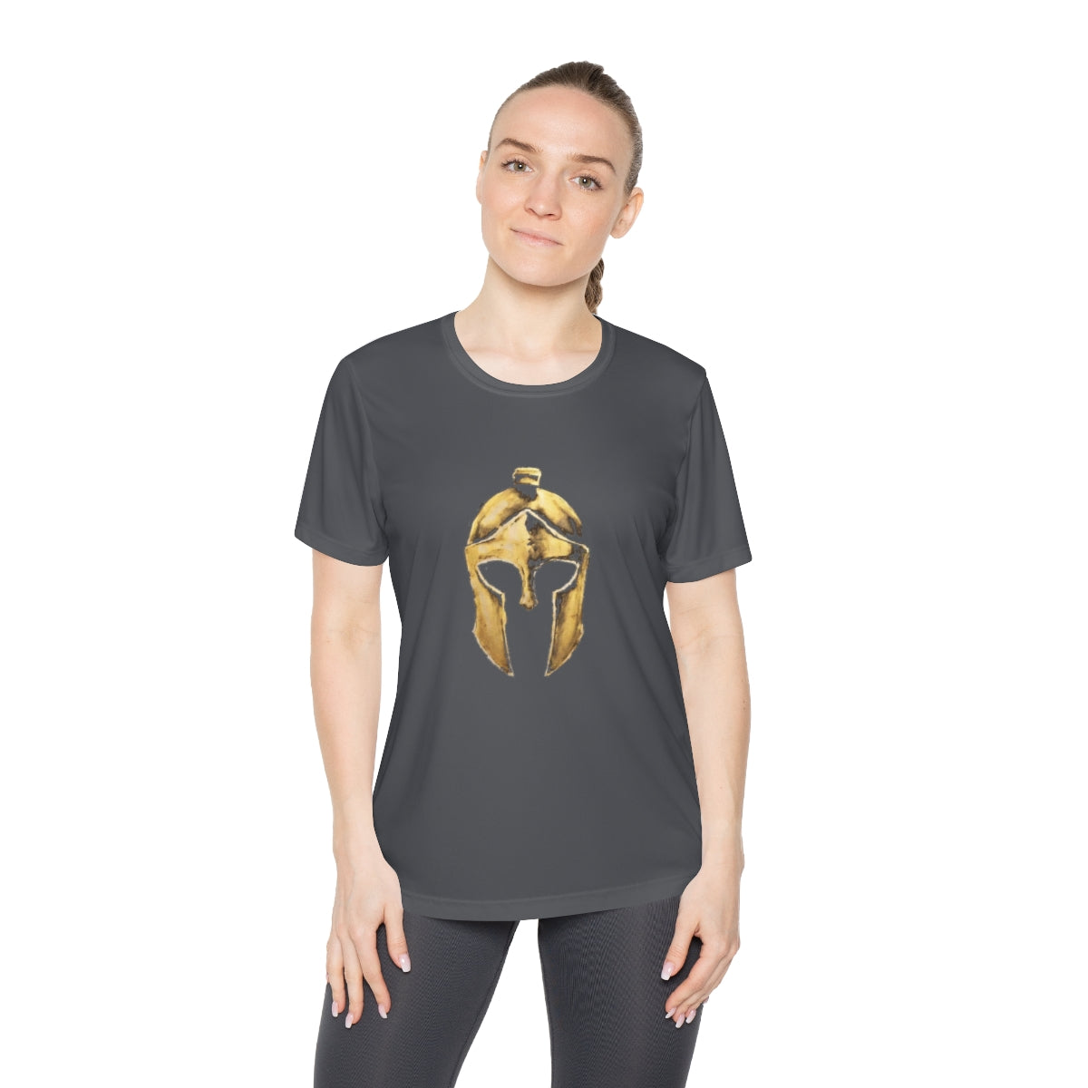 Woman wearing iron grey women's performance tee with the gold Helm helmet on the front